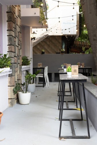 Outdoor patio dining area with tables, chairs, and hanging string lights